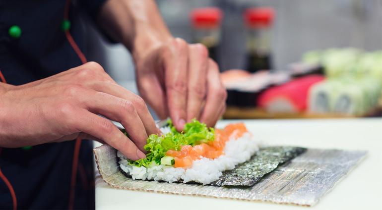 Kucharz Zawija Rolki Sushi.