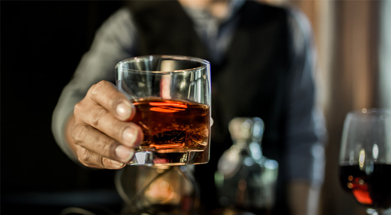 Mężczyzna podaje szklankę w whisky