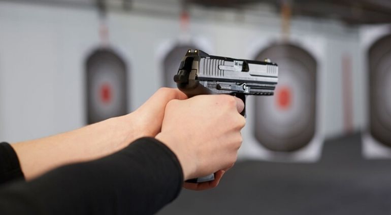Mężczyzna Trzyma Broń Krótką I Przymierza Się Do Strzału