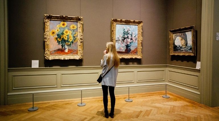 Kobieta Przypatruje Się Trzem Obrazom W Muzeum