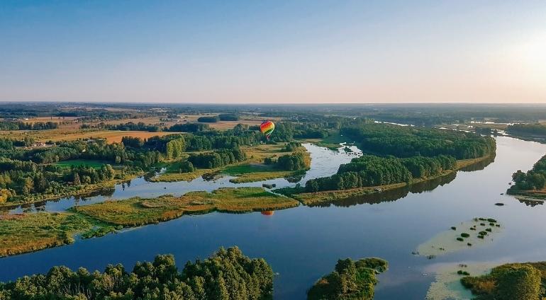 Lot balonem na tle jeziora i lasu