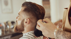 Brodaty mężczyzna na fotelu u barbera