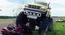 Biały Monster Truck Wjeżdża Na Samochód i Rozrzuca Błoto